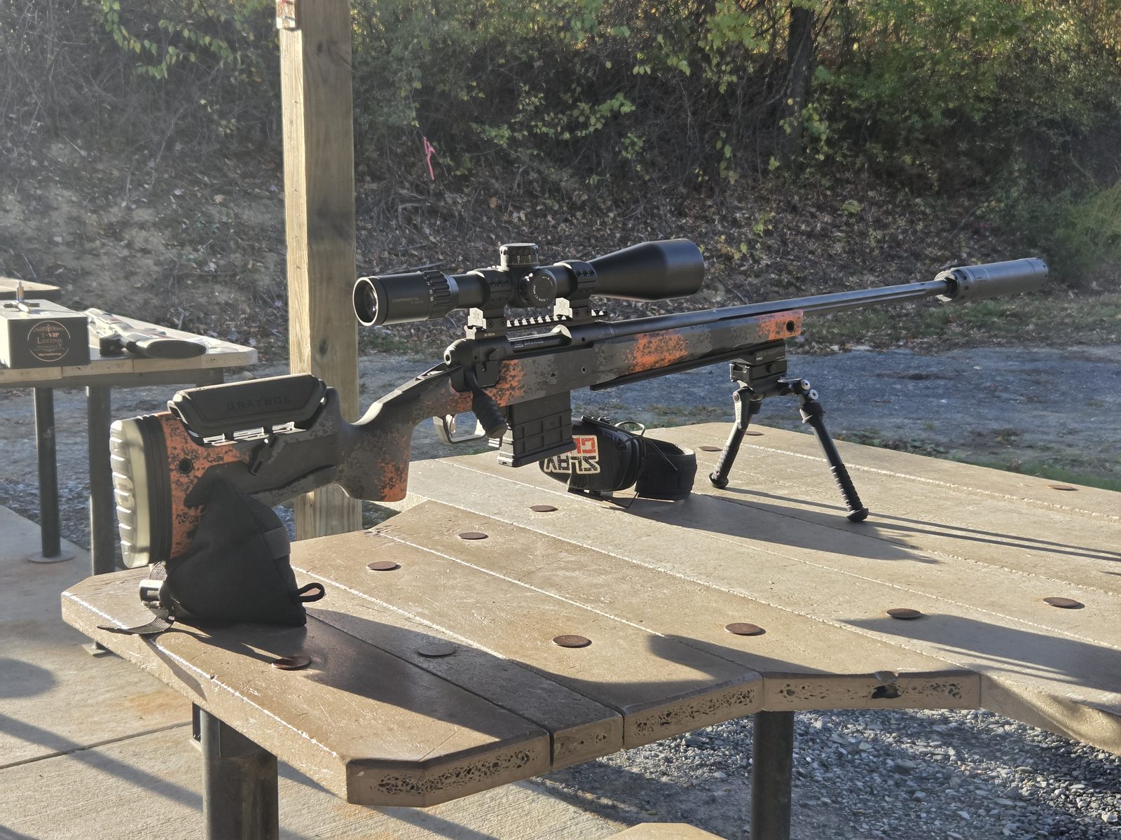 Rifle in a Grayboe Core stock set up on a bipod at an outdoor range bench